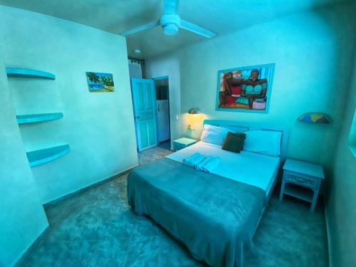 a blue bedroom with a bed and a ceiling fan at Villa 20 in Las Terrenas