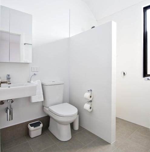 a white bathroom with a toilet and a sink at Margaret River Bungalow-3-forest - pet friendly in Margaret River Town