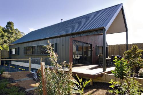 a small house with a black roof at Margaret River Bungalow-3-forest - pet friendly in Margaret River Town