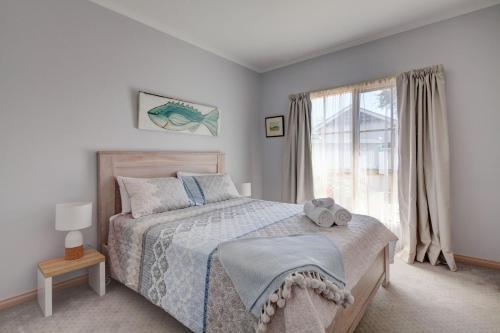 a bedroom with a bed and a window at Avalon Cottage in Port Fairy