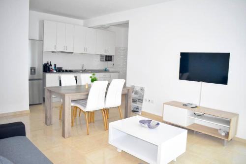 uma sala de estar com uma mesa e uma cozinha em Lovely - Luxury 3 Bedrooms 500m from the Beach. em Santa Maria