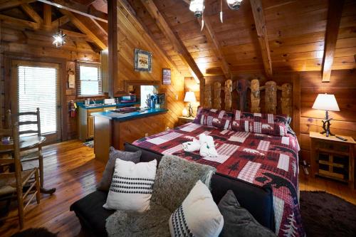 um quarto com uma cama num chalé de madeira em Gatlinburg Area Hottub Cabin - Ladyslipper em Sevierville