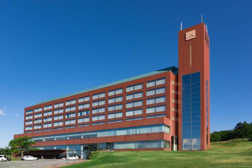 a large red building with a clock tower at Rockwood Hotel & Spa in Ajigasawa