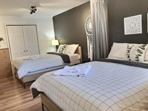 a bedroom with two beds with towels on them at Le Relais de la Martine in Petite-Rivière-Saint-François
