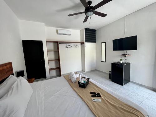 1 dormitorio con 1 cama y TV de pantalla plana en BALAM Playa - 15Th Ave en Playa del Carmen