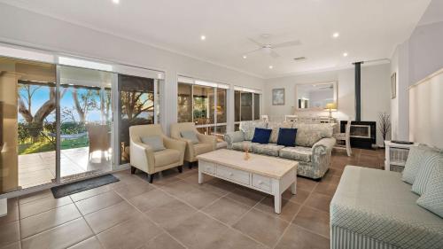a living room with a couch and a table at Sunset Beach Luxury 24 in Soldiers Point