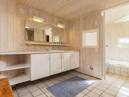 Holiday home Otterup XVIII في Otterup: حمام مع حوض ومرآة