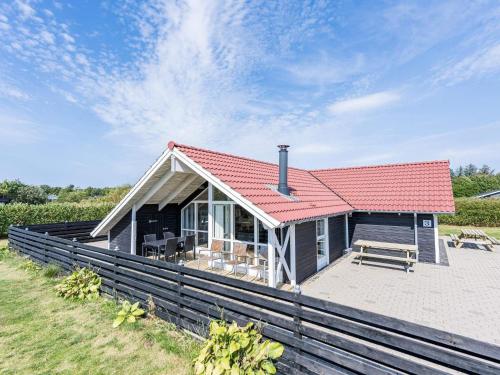 a small house with a red roof on a beach at 8 person holiday home in Hemmet in Hemmet