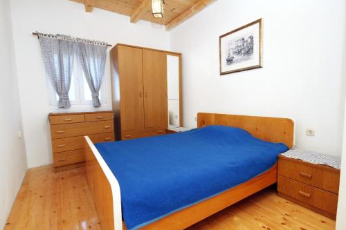 Schlafzimmer mit einem blauen Bett und Holzschränken in der Unterkunft Holiday house with a parking space Lukoran (Ugljan) - 6234 in Lukoran