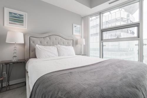una camera da letto bianca con un letto grande e una finestra di MMG Executive Suite - VIEWS FROM THE TOP a Toronto