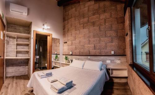 a bedroom with a bed and a brick wall at Casa Nahia Hostal Rural in Lorca