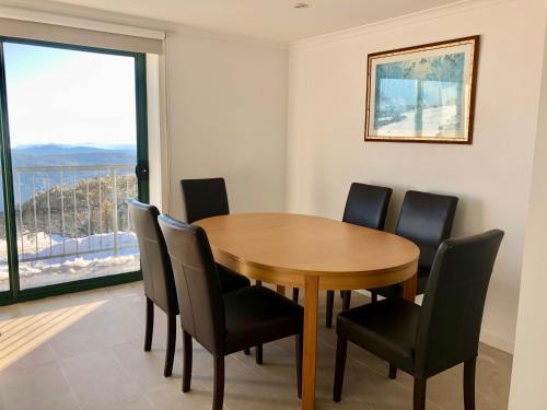 een eetkamer met een tafel en stoelen en een raam bij Arlberg 204 Ski-In Ski-Out Studio Apartment in Mount Buller