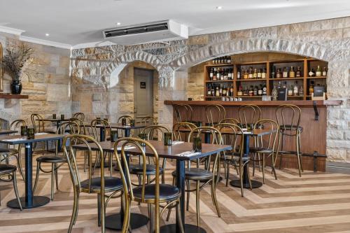 um restaurante com mesas e cadeiras e um bar em Wildes Hotel Kangaroo Valley em Kangaroo Valley