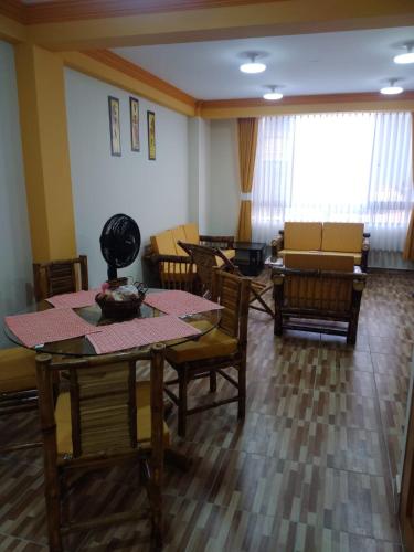 - un salon avec des tables, des chaises et un canapé dans l'établissement ACOGEDOR DEPARTAMENTO, à Coroico