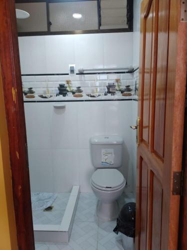 La salle de bains est pourvue de toilettes blanches. dans l'établissement ACOGEDOR DEPARTAMENTO, à Coroico