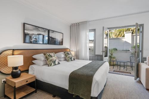 a bedroom with a large bed and a balcony at Wildes Hotel Kangaroo Valley in Kangaroo Valley