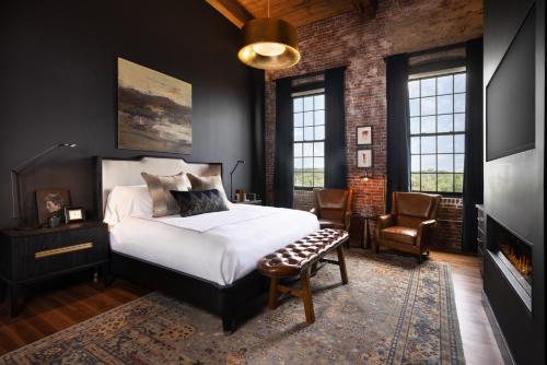 um quarto com uma cama grande e uma lareira em The Lincoln Hotel em Biddeford