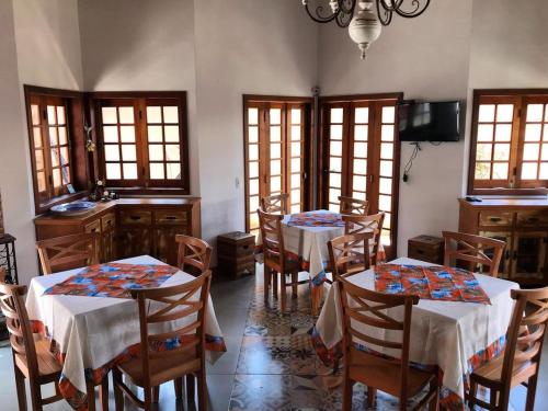 une salle à manger avec deux tables et des chaises dans l'établissement Chalés do Alferes, à Tiradentes