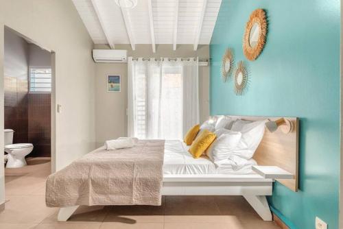 une chambre avec un lit et un mur bleu dans l'établissement Villa de Standing avec piscine au Gosier, au Gosier