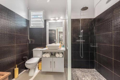 une salle de bain avec toilettes, lavabo et douche dans l'établissement Villa de Standing avec piscine au Gosier, au Gosier