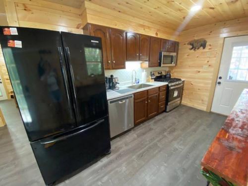 a kitchen with a black refrigerator and wooden cabinets at Paradise at the Smokies Cabin in Sevierville