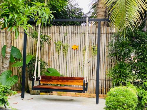 a swinging bench in front of a fence at Siya Private Pool Villa Ao Nang in Ao Nang Beach