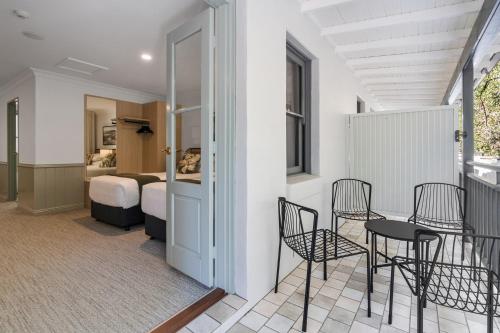 a room with a balcony with chairs and a bed at Wildes Hotel Kangaroo Valley in Kangaroo Valley