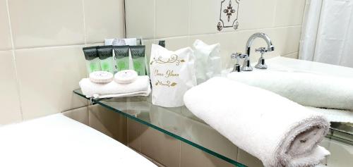 Baño con toallas en una estantería de cristal junto a un fregadero en Goldrush Motel Young CBD, en Young