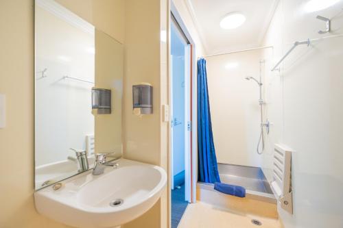 a bathroom with a sink and a shower at Te Anau Central Backpackers in Te Anau