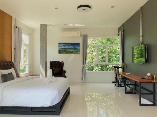 a bedroom with a bed and a desk and windows at Siya Private Pool Villa Ao Nang in Ao Nang Beach