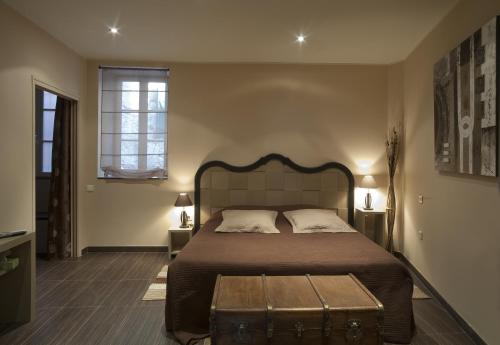 a bedroom with a large bed with a trunk on the floor at Bed & Breakfast Demeure du Pareur in Villeneuve-Minervois