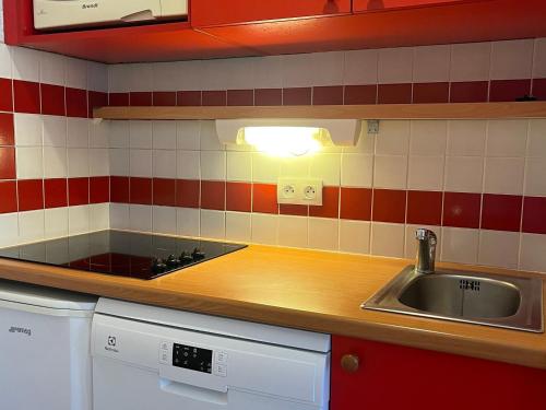 a kitchen with a sink and red and white tiles at Appartement Plagne 1800, 2 pièces, 5 personnes - FR-1-351-42 in Plagne 1800