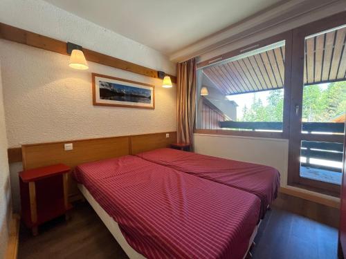 a bedroom with a red bed and a window at Appartement Plagne 1800, 2 pièces, 4 personnes - FR-1-351-40 in Plagne 1800