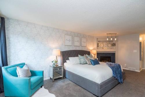 a bedroom with a large bed and a blue chair at Luxe Oasis Retreat: LG Grp, Pool, BBQ, 4BR, AC! in Winnipeg