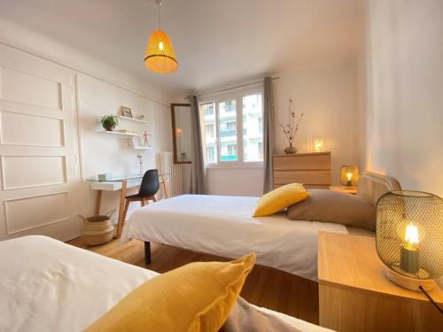 - une chambre avec 2 lits, un bureau et une table dans l'établissement Charmant T3 rénové en centre-ville d'Annecy avec balcon, ascenseur et parking privé - FR-1-432-83, à Annecy