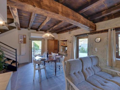 - une cuisine et une salle à manger avec une table et un canapé dans l'établissement Maison de charme 18e siècle avec jardin, parking et modernité – proche de Vichy et Charroux - FR-1-489-393, à Taxat-Senat
