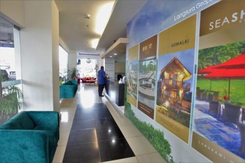 a person walking down a hallway in a building at Geopark Hotel Kuah Langkawi in Kuah