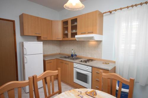 - une cuisine avec des placards en bois et un réfrigérateur blanc dans l'établissement Apartments with a parking space Tkon, Pasman - 6216, à Tkon