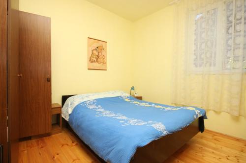 a bedroom with a bed with a blue blanket at Apartments by the sea Tkon, Pasman - 6221 in Tkon