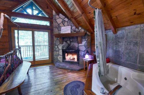 een badkamer met een bad en een open haard bij Wild Columbine - Gatlinburg Area Hottub Romantic Cabin in Sevierville