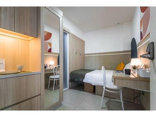 ein Schlafzimmer mit einem Bett und einem Schreibtisch sowie eine Küche in der Unterkunft Cove T63 in Jakarta