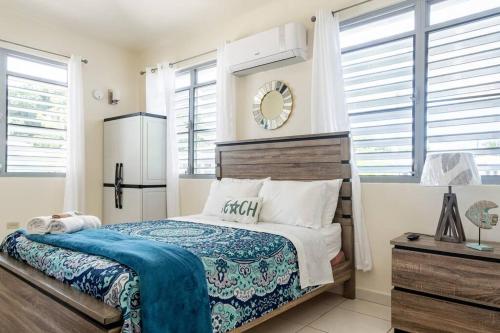 Beautiful Ocean Front Villa في أغوادا: غرفة نوم بسرير وثلاجة ونوافذ