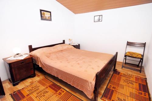 a bedroom with a bed and a table and a chair at Holiday apartments Veli Iz, Iz - 6253 in Mali Iž