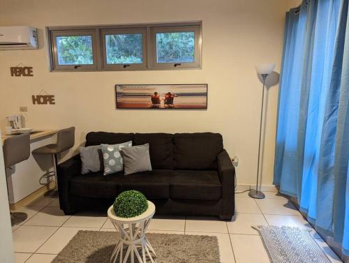 a living room with a black couch and a table at Beautiful Ocean Front Villa in Aguada