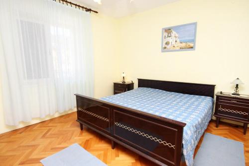 a small bedroom with a bed and a window at Apartments by the sea Veli Iz, Iz - 6255 in Veli Iž