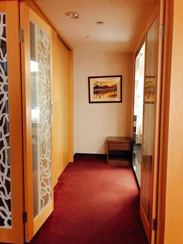 a hallway with orange walls and a red carpet at Golden Tulip Zhong Xin Hotel Taichung in Taichung