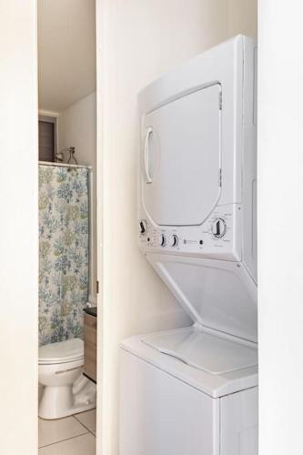 a bathroom with a washer and dryer and a toilet at Beautiful Ocean Front Villa in Aguada
