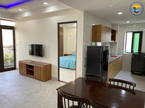 a kitchen and dining room with a table and a room with a bed at Coastal House Nha Trang in Nha Trang