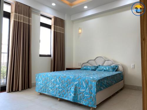 una camera da letto con letto con lenzuola e finestre blu di Coastal House Nha Trang a Nha Trang