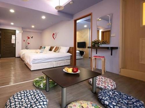 ein Schlafzimmer mit einem Bett und einem Tisch mit einer Schale Obst in der Unterkunft Hotel Blessings in Kaohsiung